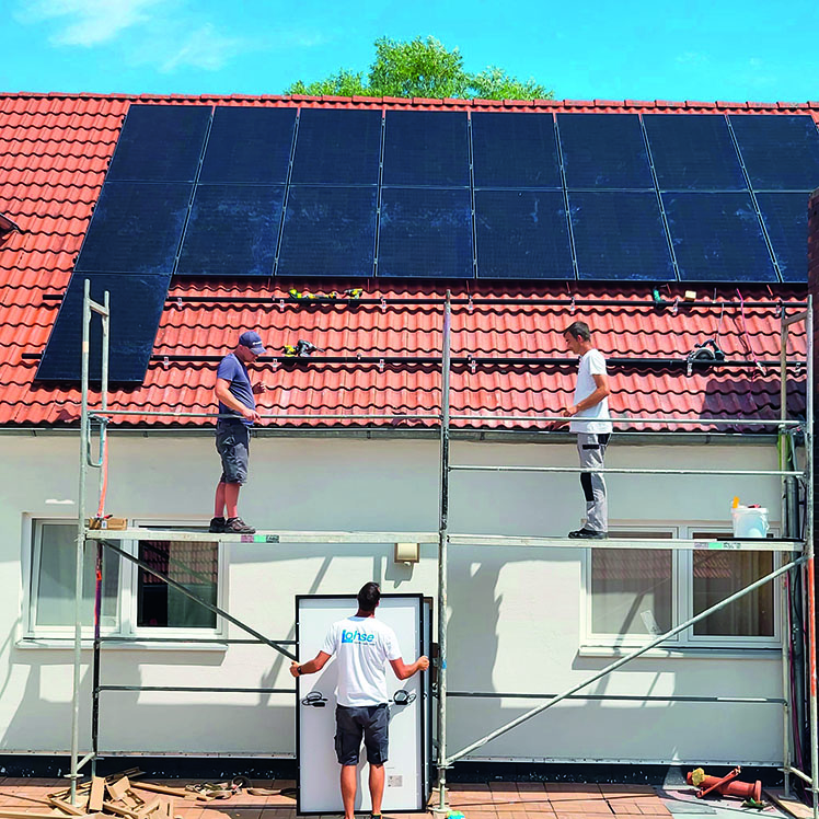 Auf einem Dach werden Solarpanels montiert